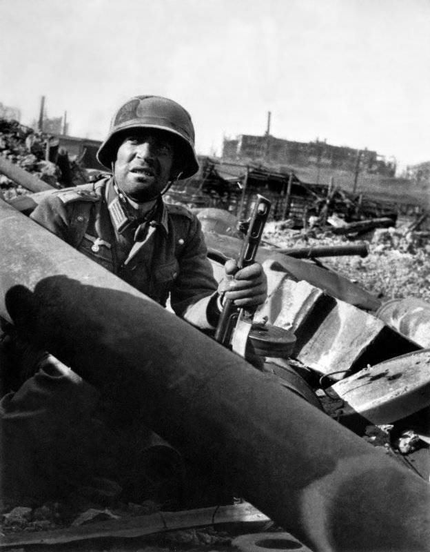 Немецкий обер-лейтенант с трофейным советским автоматом ППШ на развалинах Сталинграда