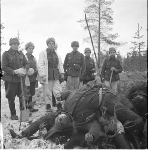 Финская похоронная команда позирует на фоне погибших 9 декабря бойцов 3-й роты 81-го гсп. Фото из финского архива Зимней войны http://sa-kuva.fi