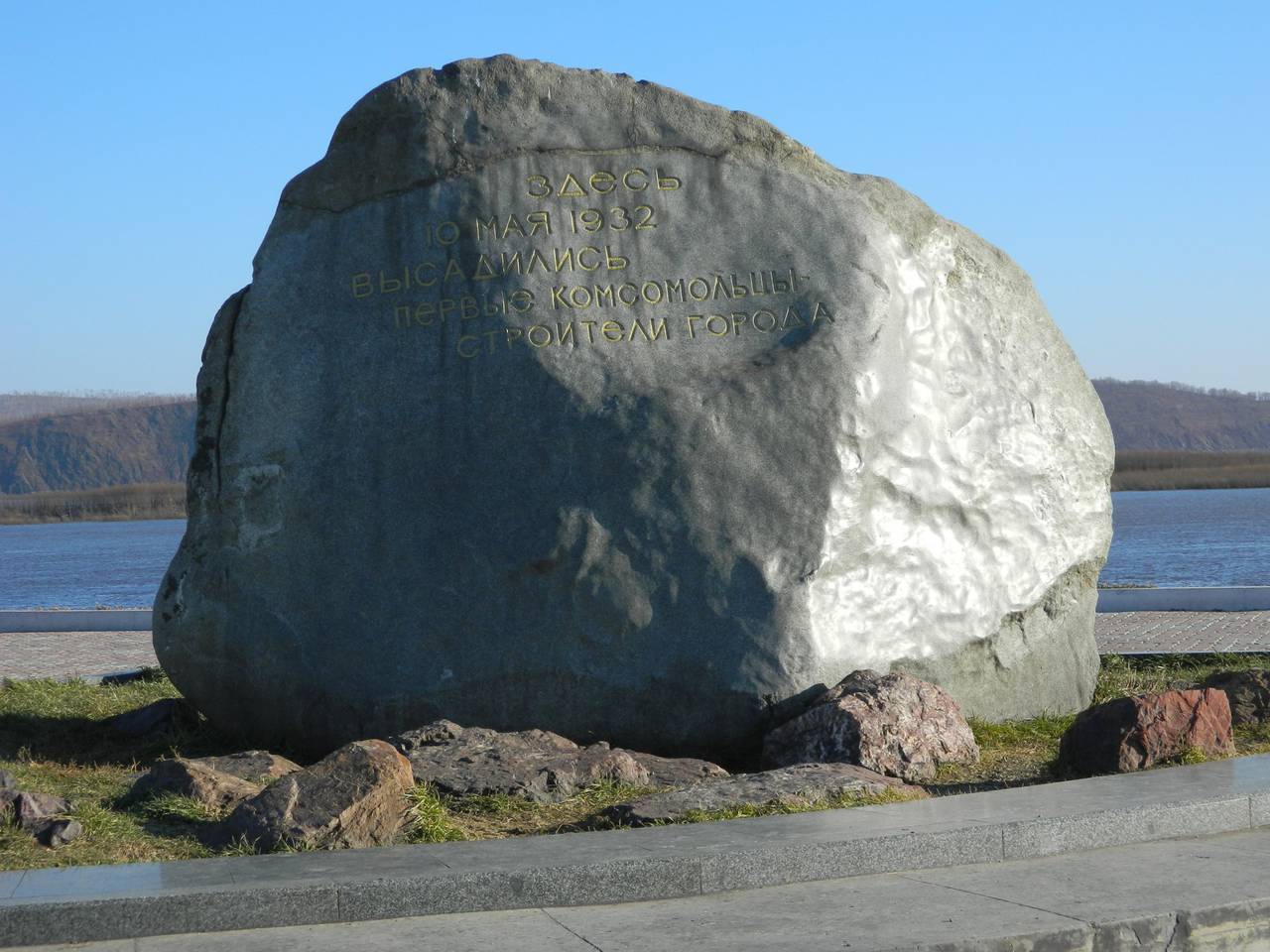 First stone. Камень первостроителям Комсомольск на Амуре. Комсомольск-на-Амуре камень памятный камень. Памятный камень на набережной Комсомольска-на-Амуре. Памятный камень города Комсомольска на Амуре.