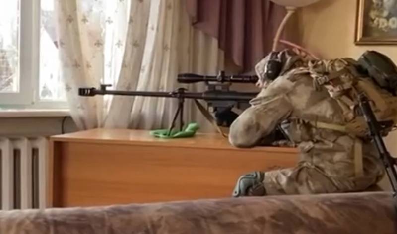 Một tay súng bắn tỉa của Lực lượng Vũ trang Ukraine, trang bị đồ đạc cho vị trí của mình tại một trong những căn hộ, lọt vào khung hình