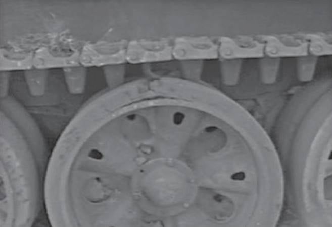 Попадание из РПГ-7 в опорный каток танка. Взрыв снаряда и кумулятивная струя хорошо его потрепали, раздробив шину. Однако до основной брони борта струя не дошла, поэтому машина в общем-то цела.