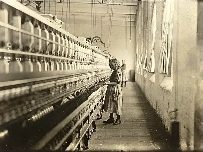 Una ragazza in una fabbrica di tessitura. Fotografia di Lewis Hine