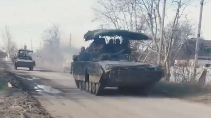 Shots of Russian T-80UE and BMP-2 tanks with anti-drone visors and additional armor are shown